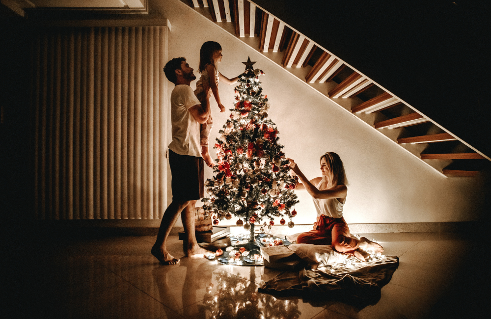 A family in an empty house around a Christmas tree.