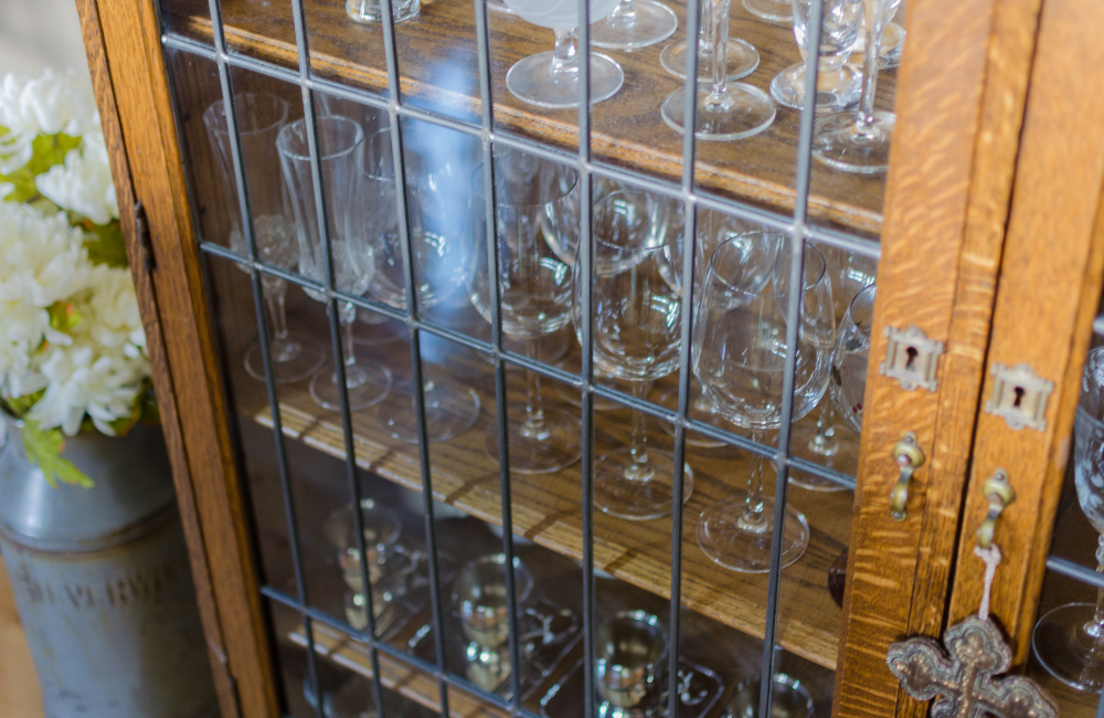 A cabinet with glass doors filled with glassware. 